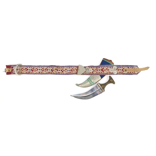 90 - Omani Jambiya dagger with horn handle and white metal mounts on embroidered belt, the dagger 39.5cm ... 