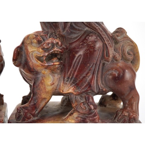 77 - Good pair of Chinese soapstone carvings of Guanyin seated on a mythical animal, each 21cm high