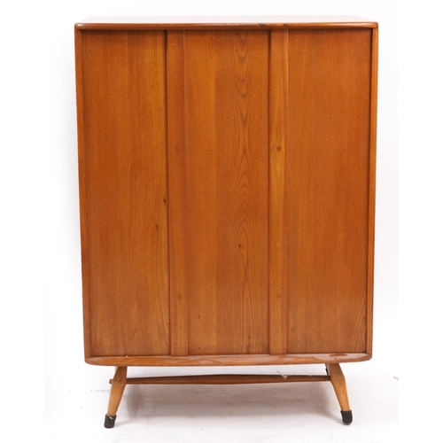 869 - Ercol light elm tallboy fitted with a fall above two cupboard doors and base drawer, 116cm H x 83cm ... 