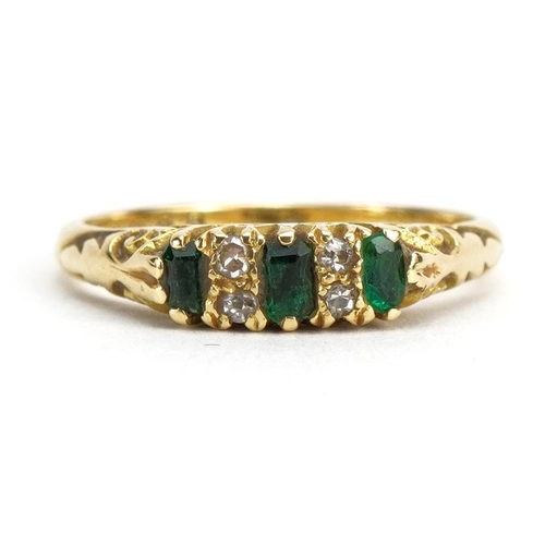 1106 - 18ct gold emerald and diamond seven stone ring with scrolled shoulders, size I/J, 2.6g