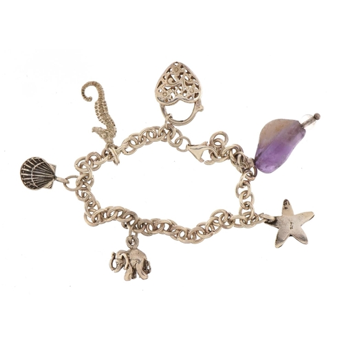 1553 - Silver charm bracelet with a selection of mostly silver charms including elephant, starfish and amet... 