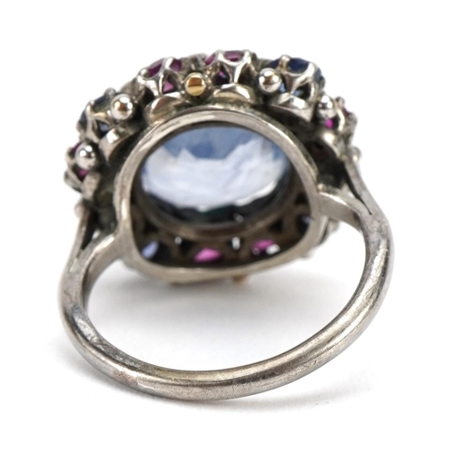 1519 - Silver blue stone and ruby cluster ring, some test as sapphires, the central stone approximately 11.... 