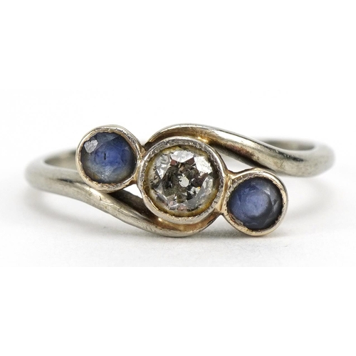 1109 - Unmarked white gold diamond and sapphire three stone crossover ring, the diamond approximately 3.9mm... 