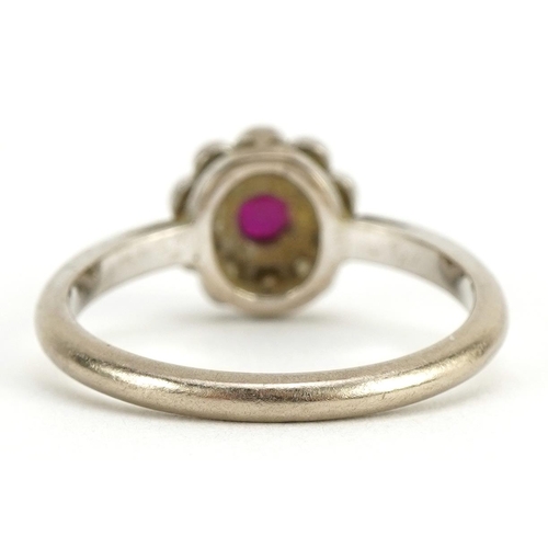 1051 - Unmarked white gold ruby and diamond two tier flower head ring, tests as 18ct gold, size K/L, 3.0g