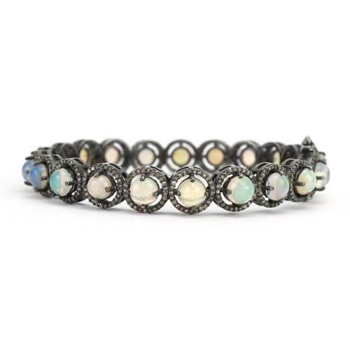 1007 - White metal cabochon opal and diamond hinged bracelet, 7.2cm in diameter, 23.7g