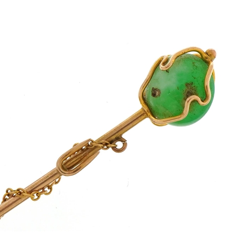 1101 - Unmarked gold green hardstone and pearl stickpin with chain, housed in a tooled leather box, 7.3cm i... 