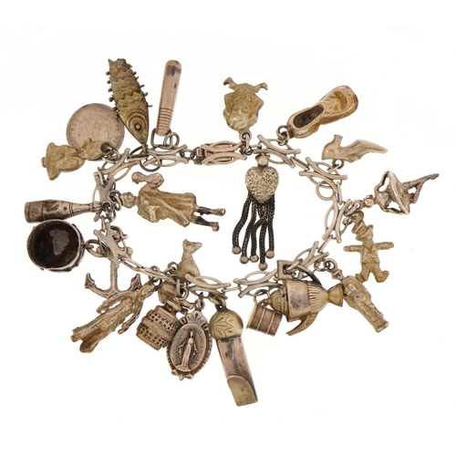 1521 - Unmarked silver charm bracelet with a selection of mostly silver charms including whistle, articulat... 