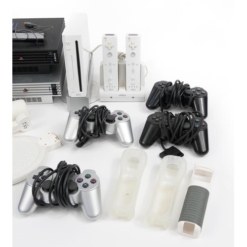 341 - Two PlayStation 2 games consoles and a Nintendo Wii games console with controllers and accessories