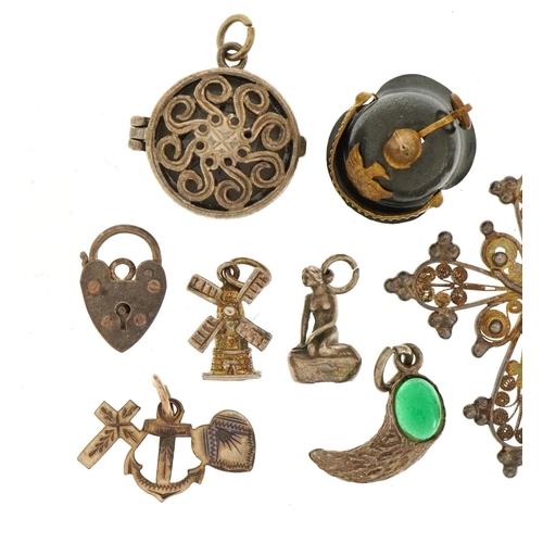 1556 - Collection of silver and white metal charms and pendants including a Pickelhaube helmet, crucifix an... 