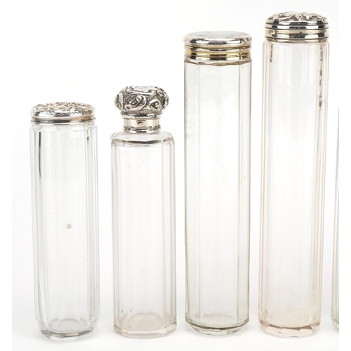 152 - Seven Edwardian and later cut glass jars with silver lids, some with embossed decoration, various ha... 