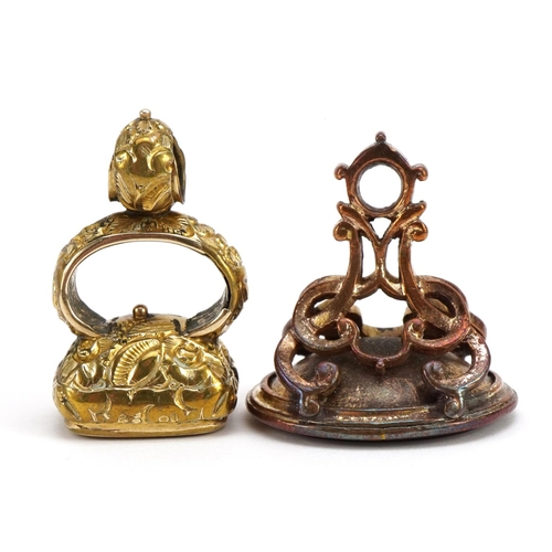 1594 - Two antique yellow metal carnelian seal fobs including one carved with a heraldic crest, the largest... 