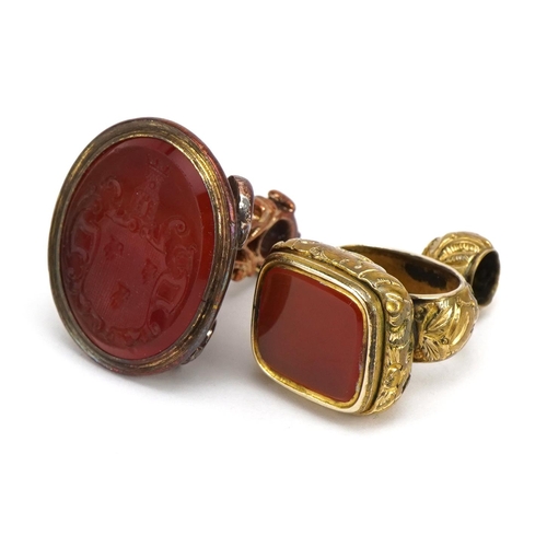 1594 - Two antique yellow metal carnelian seal fobs including one carved with a heraldic crest, the largest... 