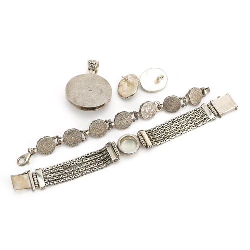 1577 - Middle Eastern silver jewellery comprising two bracelets set with cabochon stones and a pendant with... 