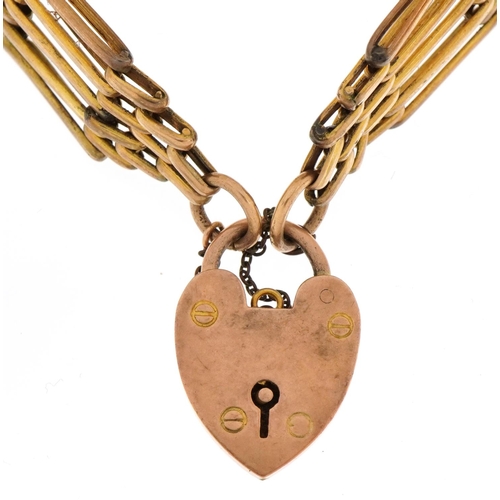 1110 - 9ct gold love heart padlock on a yellow metal five row gate bracelet , total weight 22.3g