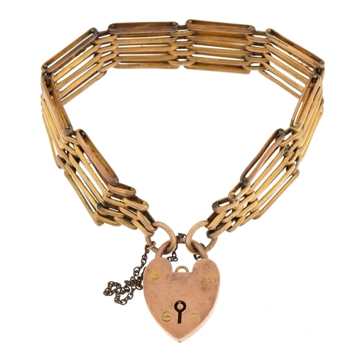 1110 - 9ct gold love heart padlock on a yellow metal five row gate bracelet , total weight 22.3g