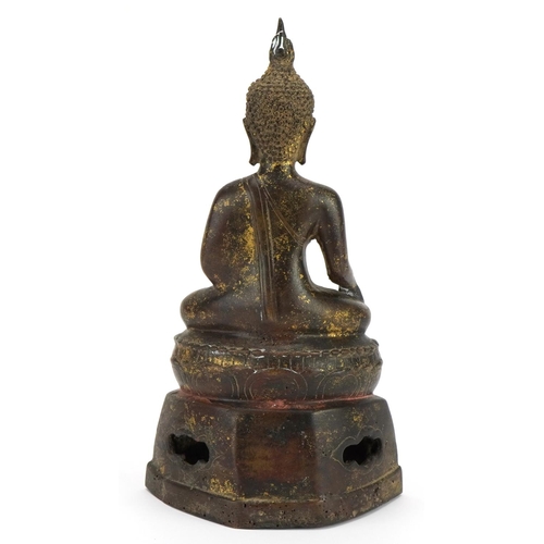 391 - South East Asian partially gilt patinated bronze figure of seated Buddha, 22cm high