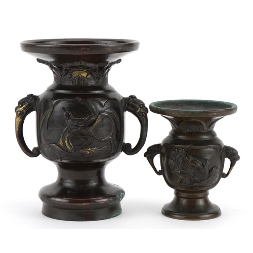 446 - Two Japanese bronze vases, each with twin elephant head handles and decorated in relief with birds a... 