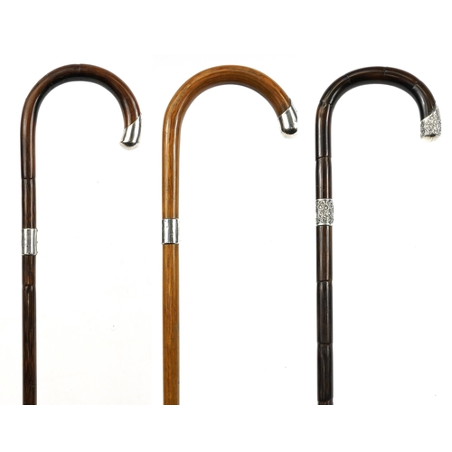 403 - Three Victorian and later bamboo and malacca walking sticks with silver mounts, the largest 93cm in ... 