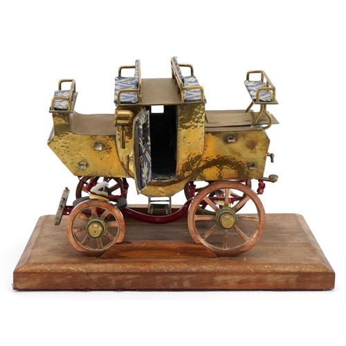 371 - Scratch built brass, copper and iron stagecoach raised on a wooden plinth base, 32cm in length