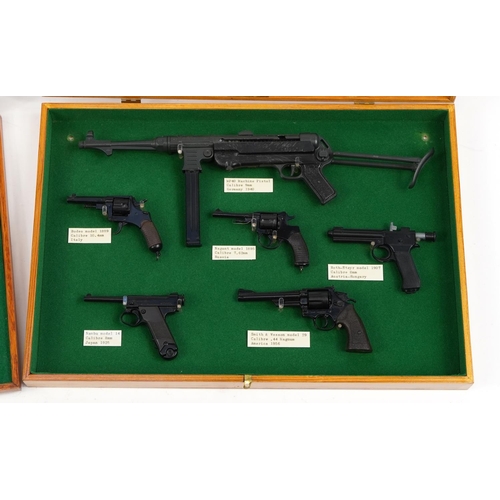 1798 - Fifteen miniature Uniwerk model hand guns arranged in two display cases including MP40 machine pisto... 