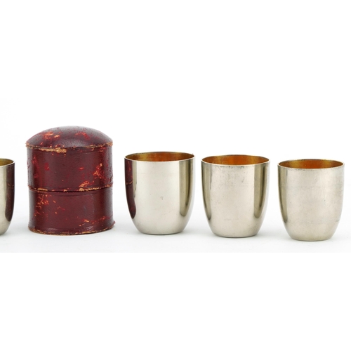 370 - WMF, graduated set of six German silver plated shot glasses with gilt interiors housed in a red leat... 