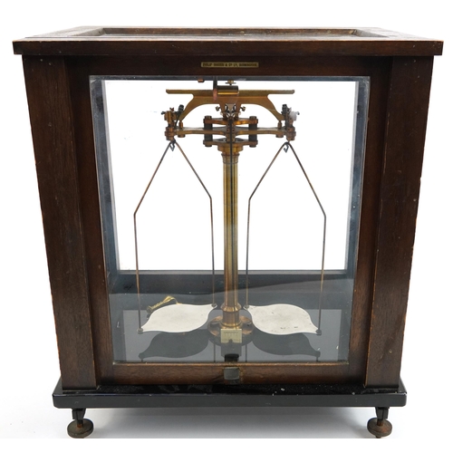 156 - Paul Bunge of Hamburg, set of brass balance scales housed in a glazed oak display case, 43cm H x 36.... 