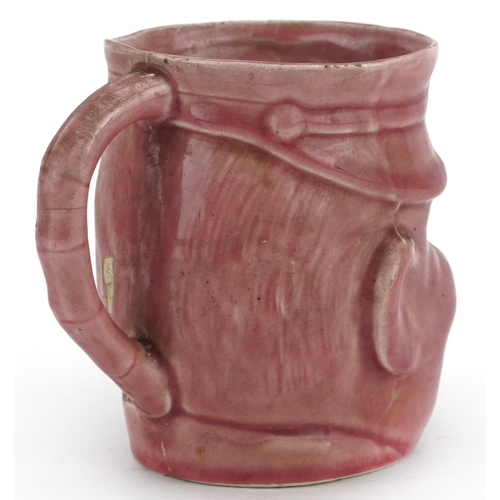 1784 - Military interest pink glazed mug in the form of a Bruce Bairnsfather's Old Bill, 11.5cm high