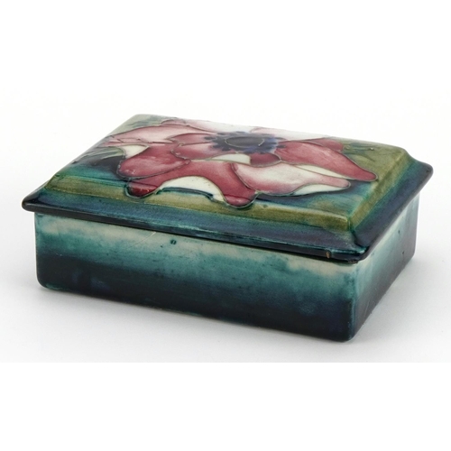 246 - William Moorcroft pottery box and cover hand painted with a flower head, 12cm wide