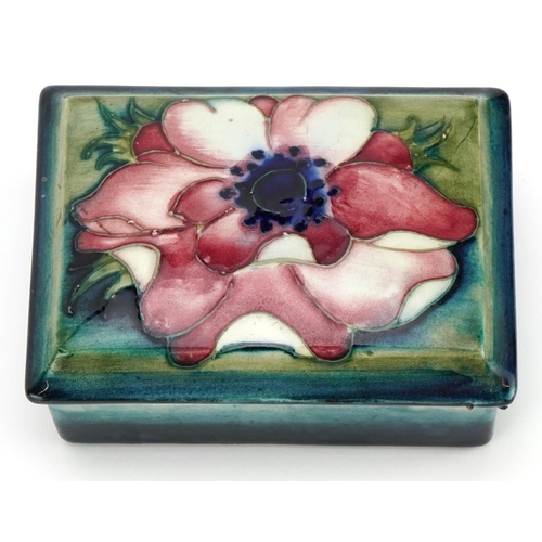 246 - William Moorcroft pottery box and cover hand painted with a flower head, 12cm wide