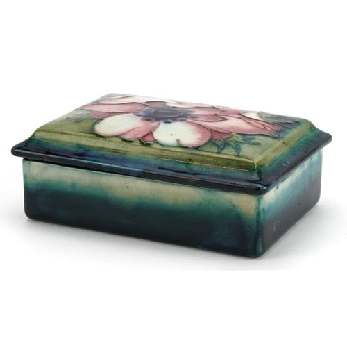 246 - William Moorcroft pottery box and cover hand painted with a flower head, 12cm wide