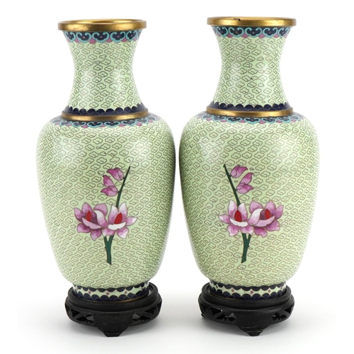 192 - Pair of Chinese cloisonne vases raised on hardwood stands, each enamelled with flowers, each 29cm hi... 