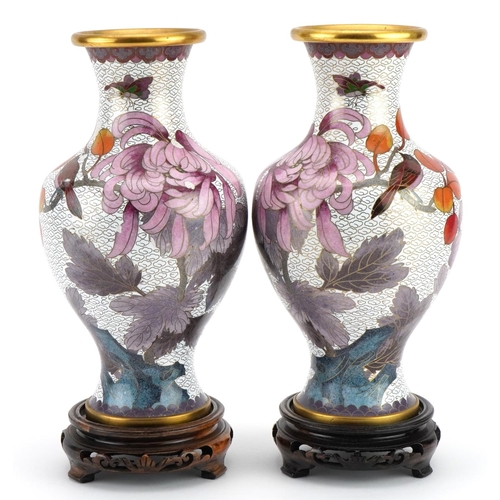 193 - Pair of Chinese cloisonne vases raised on hardwood stands, each enamelled with birds amongst flowers... 