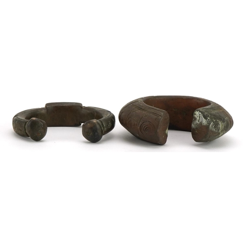 485 - Two Middle Eastern bronze slave bangles with incised decoration, the largest 10cm wide