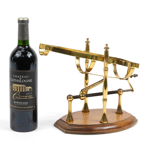 424 - Brass mechanical action wine bottle stand/pourer on wooden base with a bottle of 2015 Chateau de Cat... 