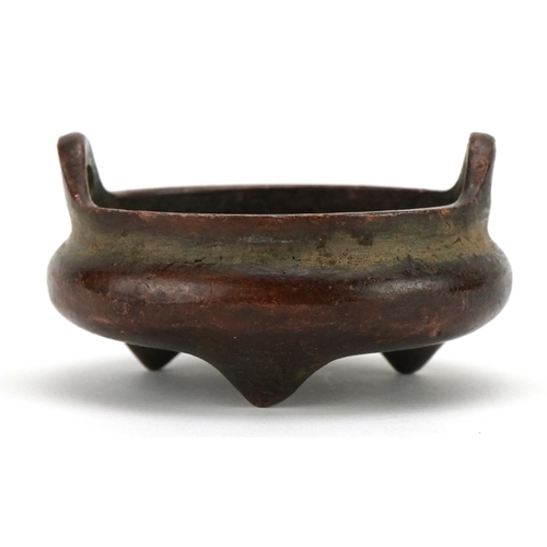 394 - Miniature Chinese patinated bronze censer with twin handles raised on three feet, character marks to... 