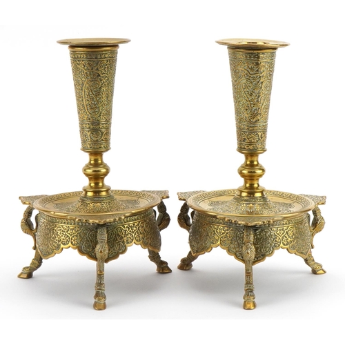 212 - Pair of good quality Indian three footed brass candlesticks engraved with flowers, each 17cm high