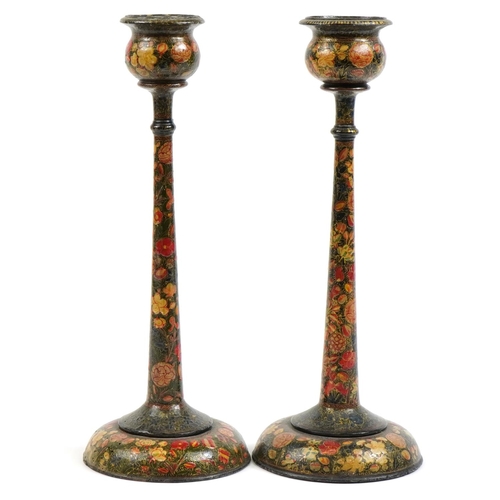 484 - Pair of Indian Kashmiri lacquered candlesticks hand painted with flowers, each 41cm high