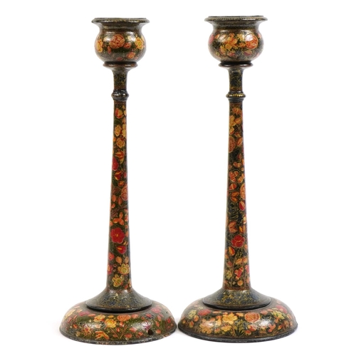 484 - Pair of Indian Kashmiri lacquered candlesticks hand painted with flowers, each 41cm high