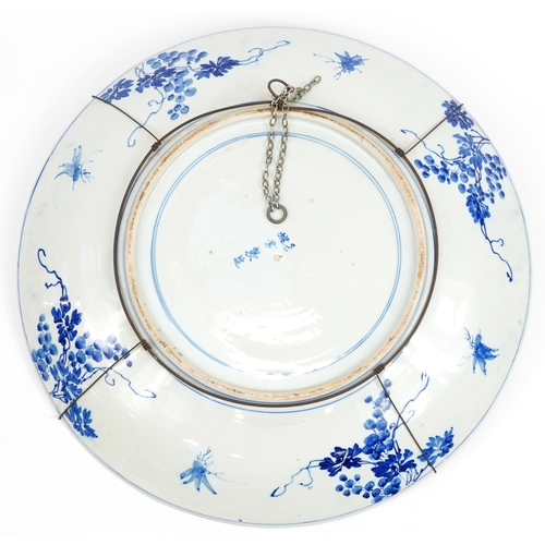 122 - Very large Japanese blue and white porcelain charger hand painted with flowers, character marks to t... 