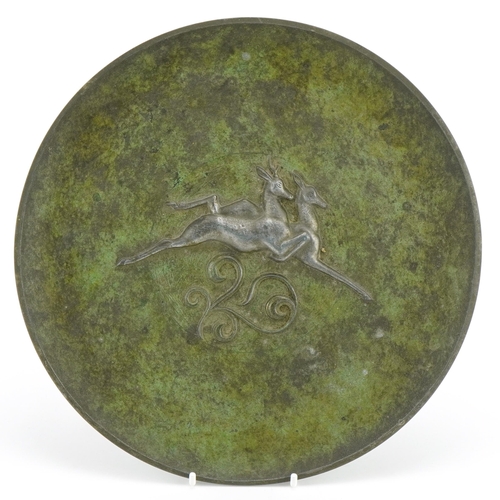 337 - Scandinavian cast metal plate decorated in relief with two leaping deer, 26.5cm in diameter