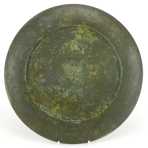 337 - Scandinavian cast metal plate decorated in relief with two leaping deer, 26.5cm in diameter