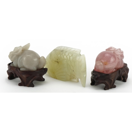 274 - Two Chinese carved jade and rose quartz rabbits with hardwood stands and a carved jade fish, the lar... 