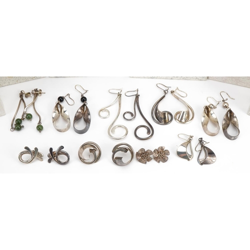 2628 - Nine pairs of silver earrings including flower head studs and one set with green stones, each housed... 