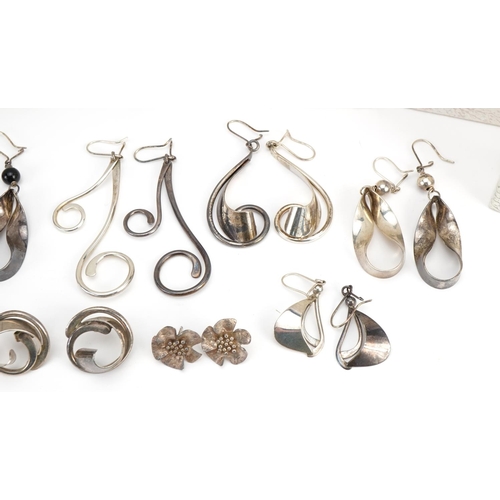 2628 - Nine pairs of silver earrings including flower head studs and one set with green stones, each housed... 