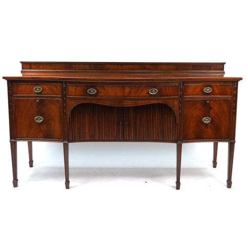 852 - Inlaid mahogany serpentine front sideboard with tambour doors, cupboard doors and drawers raised on ... 