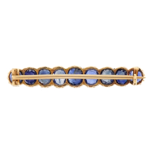 2104 - Unmarked gold sapphire brooch set with nine graduated stones housed in a velvet box, the largest sap... 