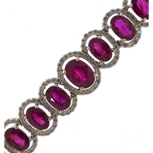 2086 - Impressive 18ct white gold graduated ruby and diamond halo bracelet, total ruby weight approximately... 