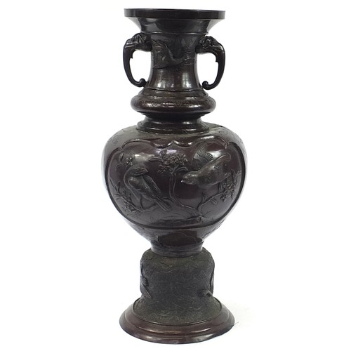 128 - Large Japanese floor standing patinated bronze vase with twin handles decorated in relief with birds... 