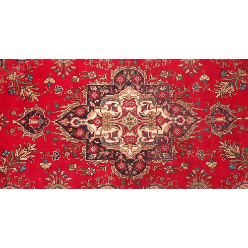 679 - Hand made Iranian carpet with stylised floral pattern onto a red and blue ground, 354cm x 254cm