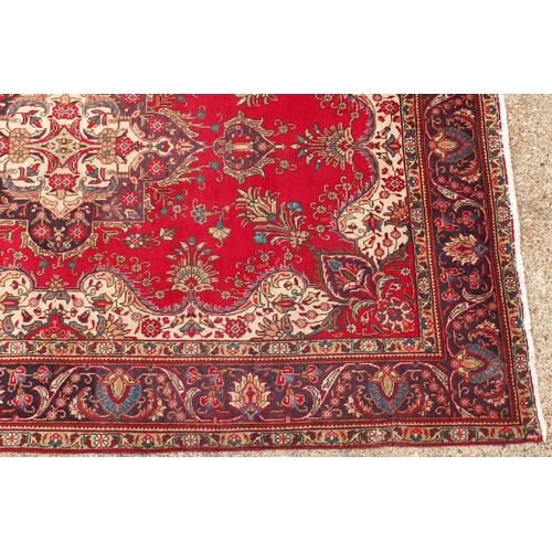 679 - Hand made Iranian carpet with stylised floral pattern onto a red and blue ground, 354cm x 254cm